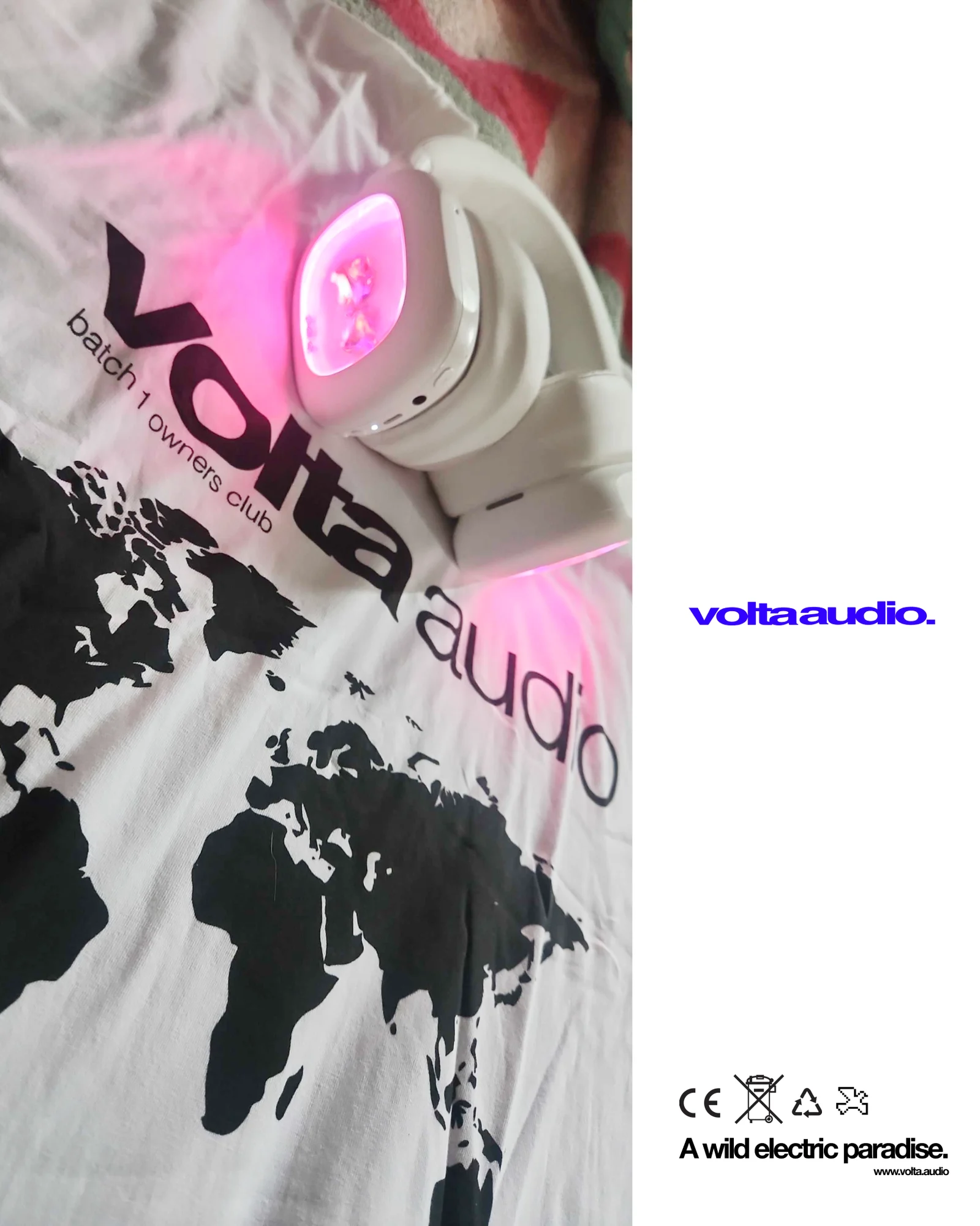 A Volta earcup glowing pink on the batch 1 owners club tee, next to the line A wild electric paradise