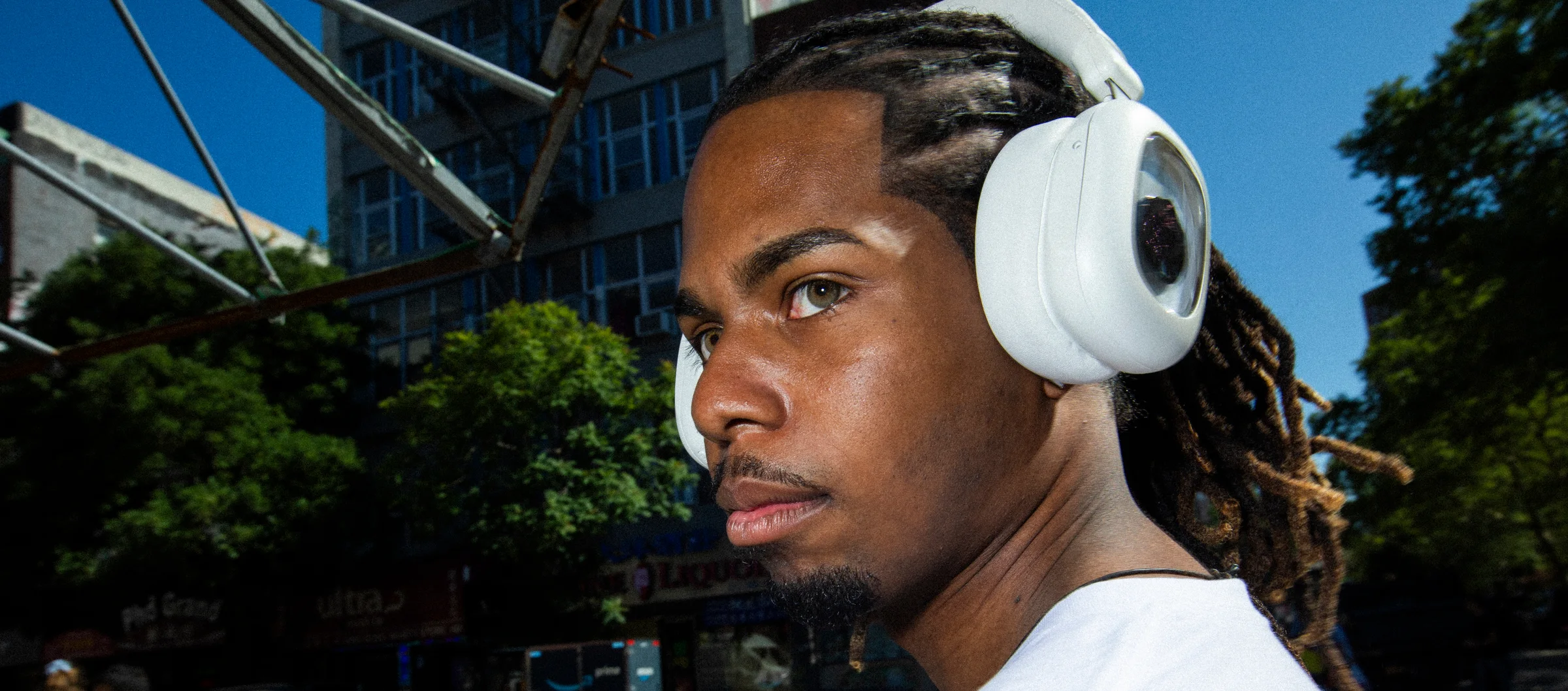 Person wearing white Volta Audio headphones on a New York street